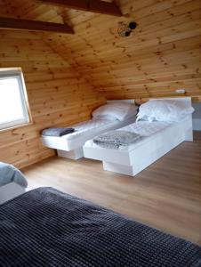 a bedroom with two beds in a wooden cabin at Przystanek Ładnówko in Kruszyny Szlacheckie