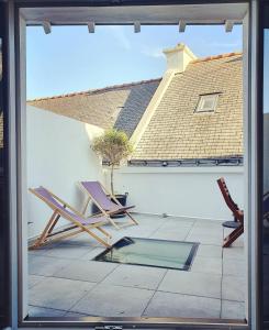 two chairs sitting on a patio outside a window at Maison de pêcheur Quiberon in Quiberon