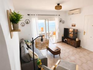 a living room with a couch and a tv at Mirador de las Gaviotas in Mojácar