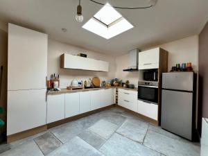 a kitchen with white cabinets and a refrigerator at Maison de pêcheur Quiberon in Quiberon