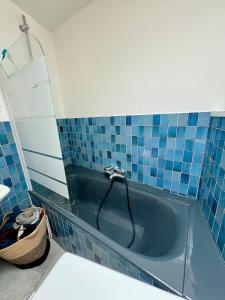 a blue tiled bathroom with a tub with a faucet at Maison de pêcheur Quiberon in Quiberon +6 photos