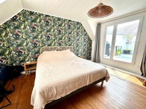 a bedroom with a bed in front of a wall at Maison de pêcheur Quiberon in Quiberon