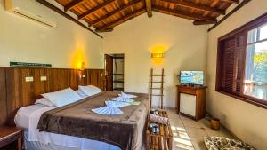 a bedroom with a bed with two towels on it at Pousada Portal do Cacau-Petfriendly in Camburi +65 photos