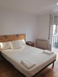 a bedroom with a large bed with two towels on it at Calle Carmen Céntrico Amplio in Pamplona
