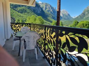 a balcony with a table and chairs and mountains at Nana Time Guesthouse in Vusanje