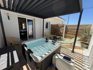 a hot tub sitting on top of a deck at Maison de campagne avec SPA in Massay