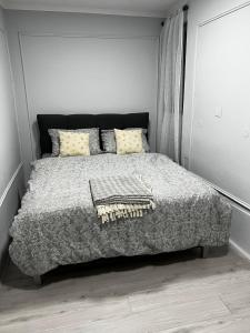 ein Schlafzimmer mit einem Bett mit grauer Bettdecke in der Unterkunft Petruccio in Zrenjanin