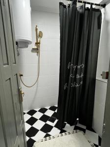 ein Badezimmer mit Dusche und schwarzem Duschvorhang in der Unterkunft Petruccio in Zrenjanin