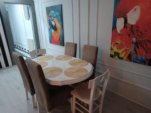 ein Esszimmer mit Tisch und Stühlen und einem Gemälde in der Unterkunft Petruccio in Zrenjanin