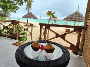 a wicker table with two coconuts on a beach at Royal Mandarin Hotel & Resort Zanzibar in Pwani Mchangani +195 photos