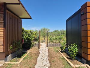 a garden with a stone path next to a building at Jasmine & Rose House in Udine +4 photos