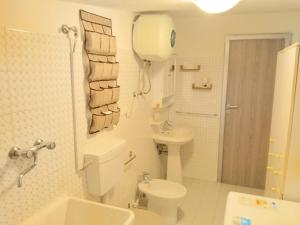 a white bathroom with a toilet and a sink at Casa Climatizzata Marina di Pisticci-Marconia in Marconia +25 photos