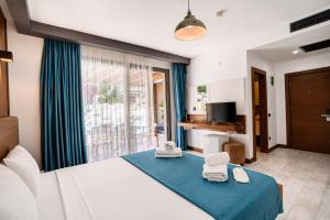 a bedroom with a bed with two towels on it at Sarum Çeşme in Çeşme