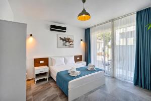 a bedroom with a bed and a large window at Sarum Çeşme in Çeşme +29 photos
