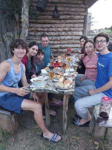 a group of people sitting around a table with food at Guesthouse Irma in Mestia