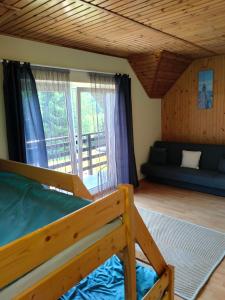a bedroom with a bed and a living room at Biały Dom - Pokoje in Wejsuny