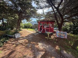 a playground in a yard under a tree at DiscoCat Studios in Ocracoke