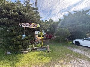 a sign for a dog cafe in a yard at DiscoCat Studios in Ocracoke