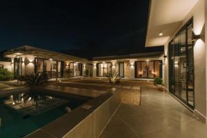 a house with a swimming pool at night at Casa Blanca Bweleo in Bweleo
