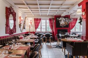 a restaurant with red walls and tables and a cow head on the wall at Hotel Le Blanche Neige in Valberg
