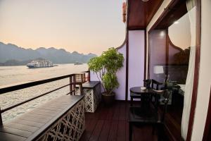 a balcony with a view of the river and a boat at Aqua Elegance Cruise - Halong Bay by AHG in Ha Long