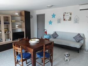 a living room with a dining room table and a dog at Casa Climatizzata Marina di Pisticci-Marconia in Marconia