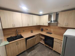 a kitchen with wooden cabinets and a sink at Žangrija in Verbiškis