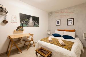 a bedroom with a bed and a desk and a table at Sun, Mountain & Adventure in Arad