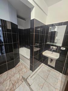 a bathroom with a sink and a toilet and a tub at Complex GEC-HISTRIA Mamaia in Mamaia