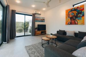 a living room with a couch and a tv at Casa Blanca Bweleo in Bweleo