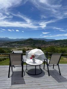 a patio with a table and two chairs and an umbrella at Džipsi glamping resort in Sarajevo +8 photos