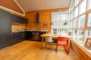a kitchen with a wooden table and some chairs at Stranda Fjellgrend 36B in Stranda