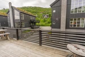 a deck with a table and benches and a building at Stranda Fjellgrend 36B in Stranda +5 photos