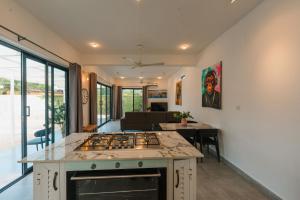 a kitchen with a stove top oven next to a living room at Casa Blanca Bweleo in Bweleo