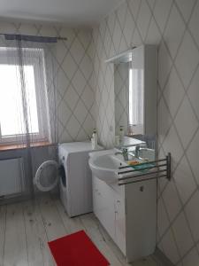 a bathroom with a sink and a washing machine at Apartament M6 w Centrum Wiela in Wiele +10 photos