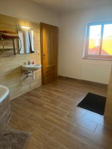 a bathroom with a sink and a tub and a window at Apartmán Netolice in Netolice