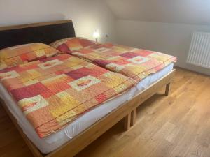 a bed with a colorful quilt on top of it at Apartmán Netolice in Netolice