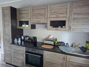 a kitchen with wooden cabinets and a counter top at Korter kesklinna piirkonnas in Tartu