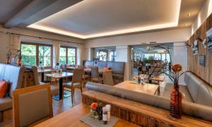 a restaurant with a couch and tables and chairs at Königslinde am Tegernsee in Bad Wiessee +10 photos