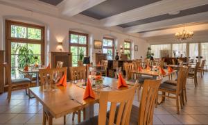 a restaurant with wooden tables and chairs and windows at Königslinde am Tegernsee in Bad Wiessee