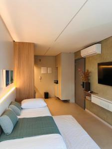 a hotel room with two beds and a tv at Wish Residence Ap 710 in Maceió +46 photos