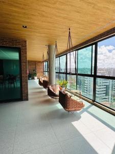 a room with a row of benches in a building with windows at Wish Residence Ap 710 in Maceió