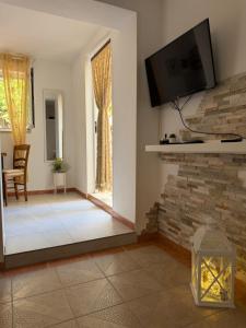a living room with a tv on a brick wall at Apartmani Grguric in Kornić