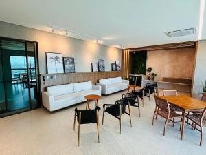 a living room with a couch and tables and chairs at Wish Residence Ap 710 in Maceió