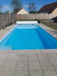 ein Swimmingpool mit blauem Wasser im Garten in der Unterkunft Chambre d'hôte 4 personnes in Magnien