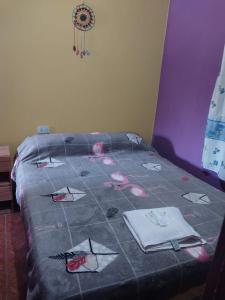 a bed with a quilt on top of it at Hostel Portal del Sol in Fiambalá