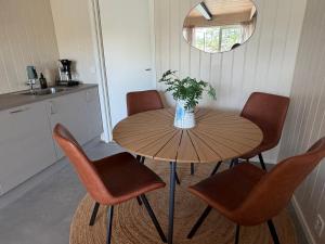 a table with chairs and a vase with a plant on it at Bird Nest in Bømlo