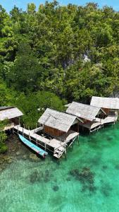 a group of bungalows and a boat in the water at BRIGHT Guest Hause in Besir