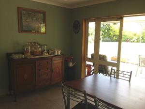 ein Esszimmer mit einem Holztisch und einem Esszimmer in der Unterkunft Newlands Bed and Breakfast in West Melton