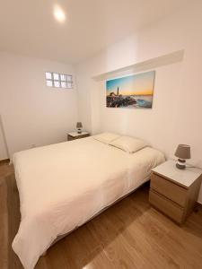 a bedroom with a white bed and a painting on the wall at Namaste in Sesimbra